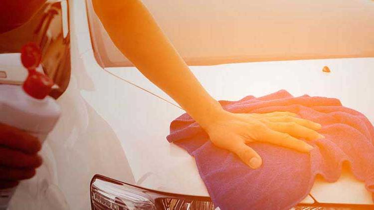 Hand resting on towel on car hood