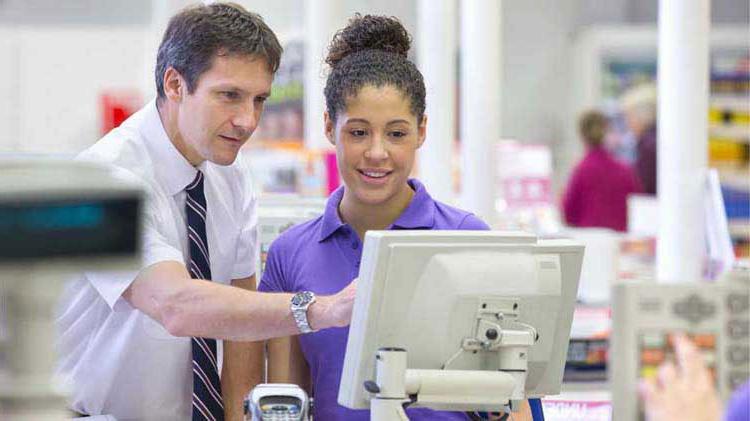 A man explains a credit card transaction to a teen.